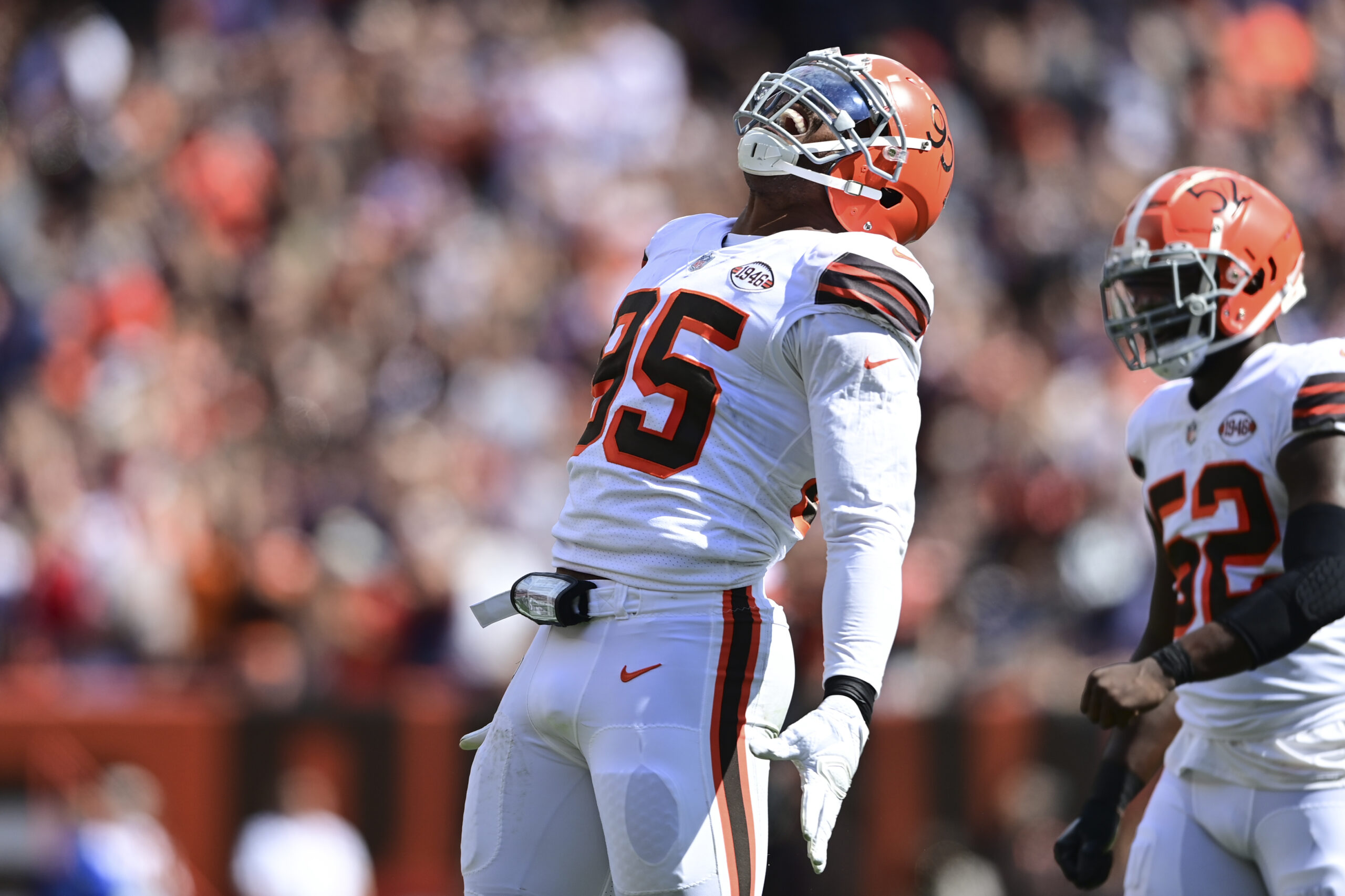 Cleveland Browns defensive end Myles Garrett, left, is restrained